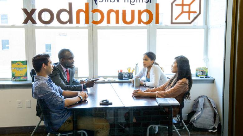 students sitting at a table interacting